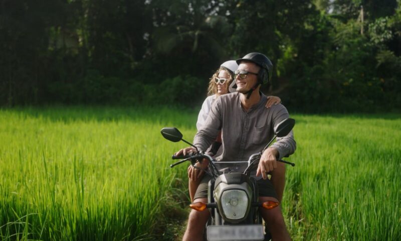 momak i devojka se voze na skuteru kroz prirodu
